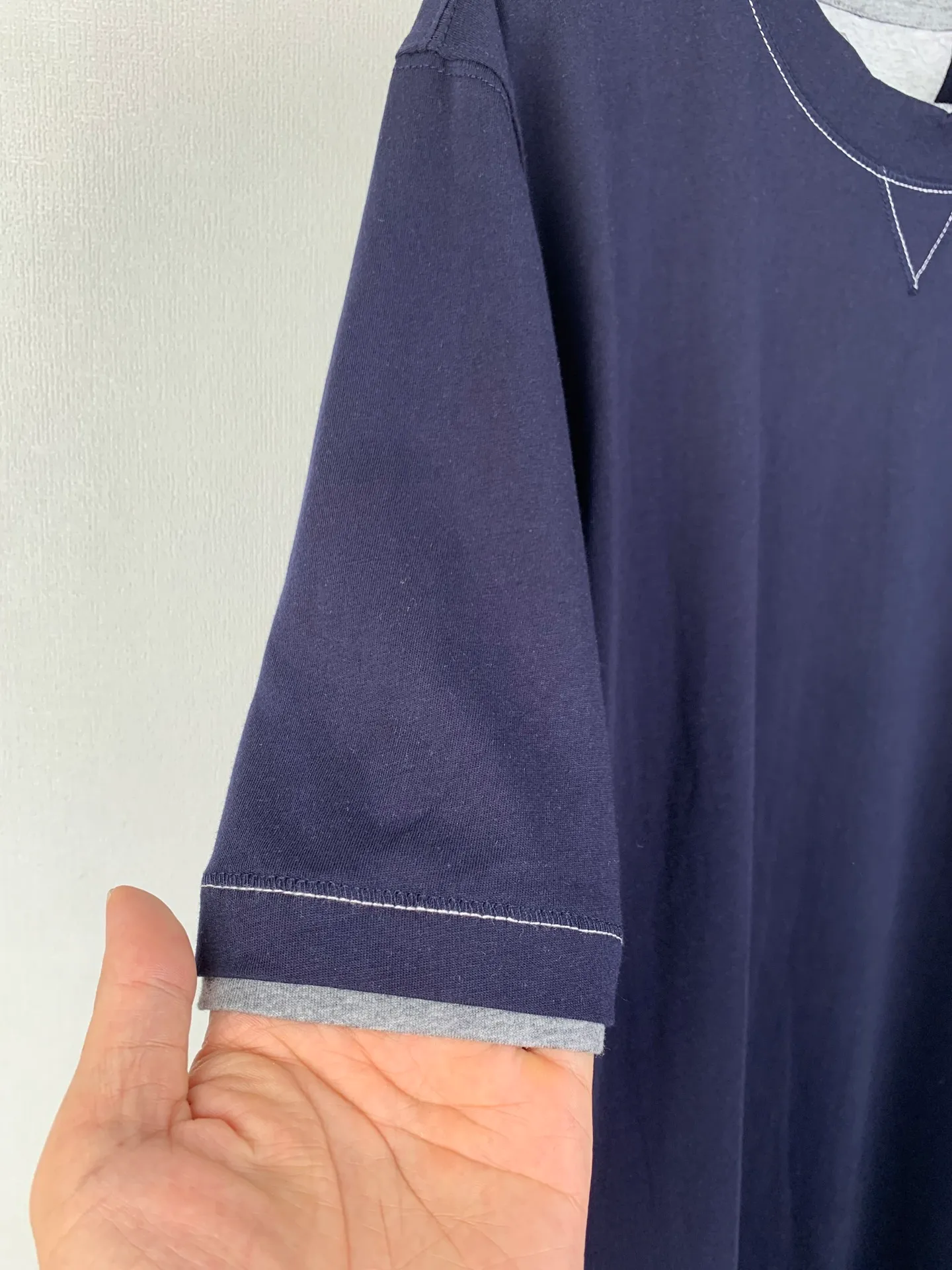 Brunello Cucinelli Fake two-piece embroidered badge stacked short-sleeved T-shirt. Customized densely woven plain organic cotton. Tight and delicate, comfortable and close to the skin. Elegant and calm navy blue is the main color. It exudes an innate sense of luxury. The round neck is decorated with sharp triangular language to visually extend the neck line. The iconic Solomeo badge is embellished on the chest. It is highly recognizable. Contrast color inlay creates a layered effect. Fake two-piece illusion aesthetics. Let the sense of high-end create unlimited imagination between likeness and dissimilarity, and there is inadvertent sophistication in every move. Process 1: Using imported machine embroidery technology, using advanced computer control systems and precision mechanical components to realize the Solomeo badge embroidery operation with high precision and smooth and delicate lines. Process 2: Using glue printing. Use glue liquid paint to print patterns on the fabric. Bake the fabric to fix the printed pattern. Technique 2: The fabrics have been washed to have a better hand texture and are not easy to deform. Not easy to shrink, not easy to fade, maintain long-term beauty Accessories: Customized 1:1 BC trademark Version: Loose version Size: S M L XL